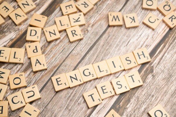 Close-up of Scrabble letter tiles on a wooden surface.